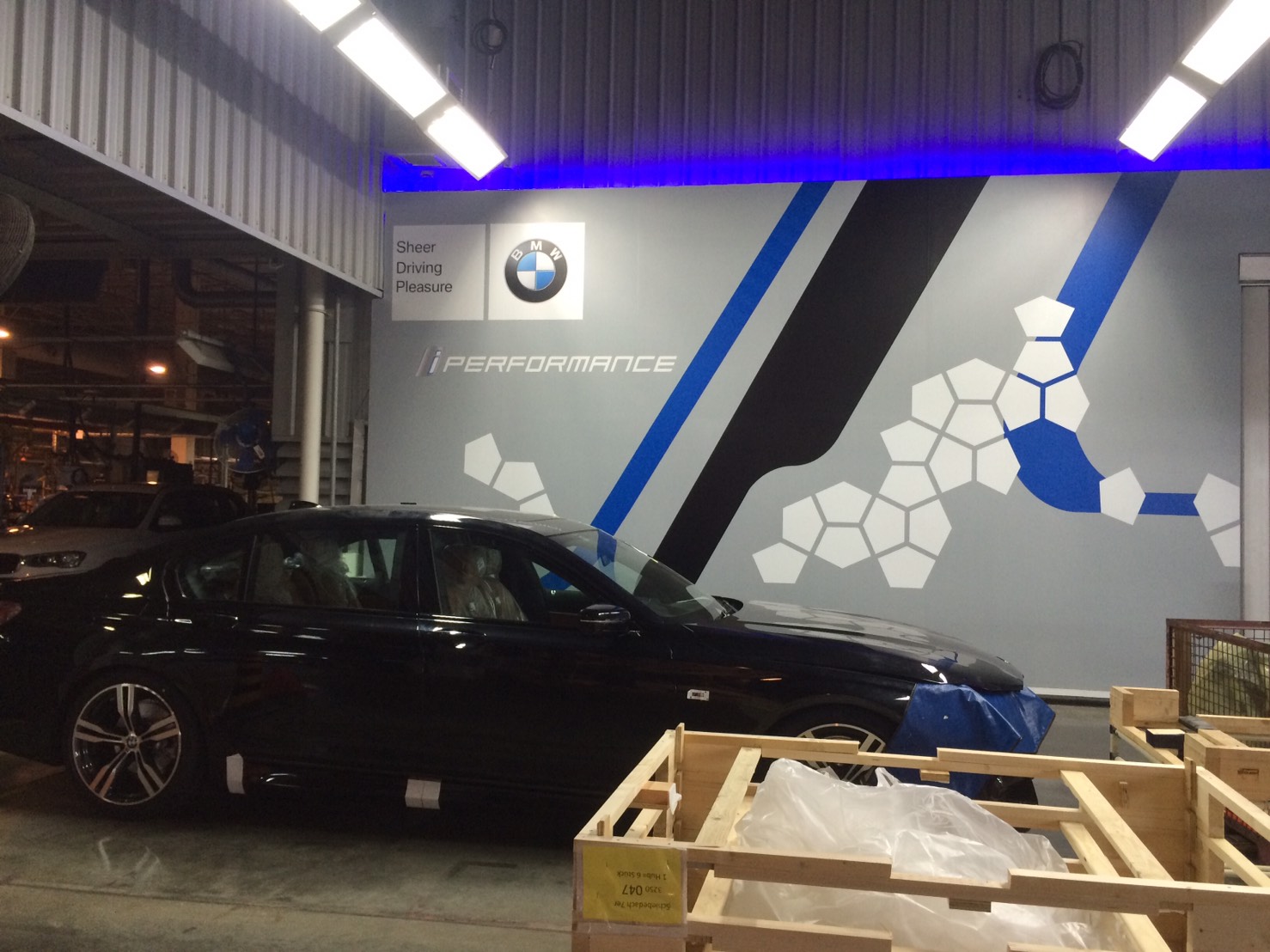 งานผลิตติดตั้ง โรงงาน BMW โครงสร้างเหล็กยึดผนัง กรุแผ่นพลาสวูด 10 มม. โปีวเก็บสี ติดสติกเกอร์ พร้อมติดตั้งราคาโรงงาน