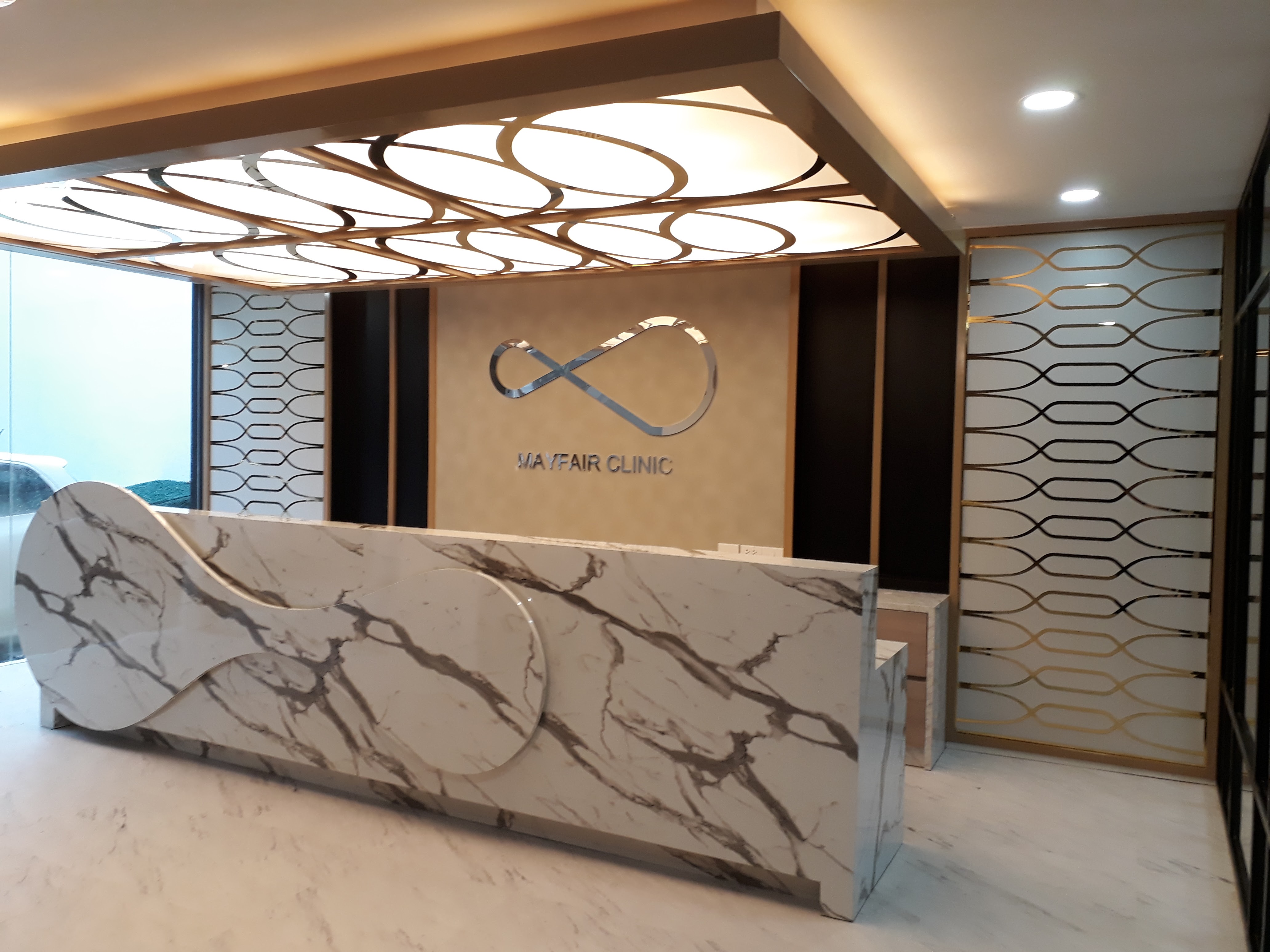งานผลิตติดตั้ง MAYFAIR CLINIC ฉลุแผ่นไทเทเนี่ยมทองเงา 1 มม. ยึดแผ่นอะคลิลิค 3 มม. พร้อมติดตั้งราคาโรงงาน