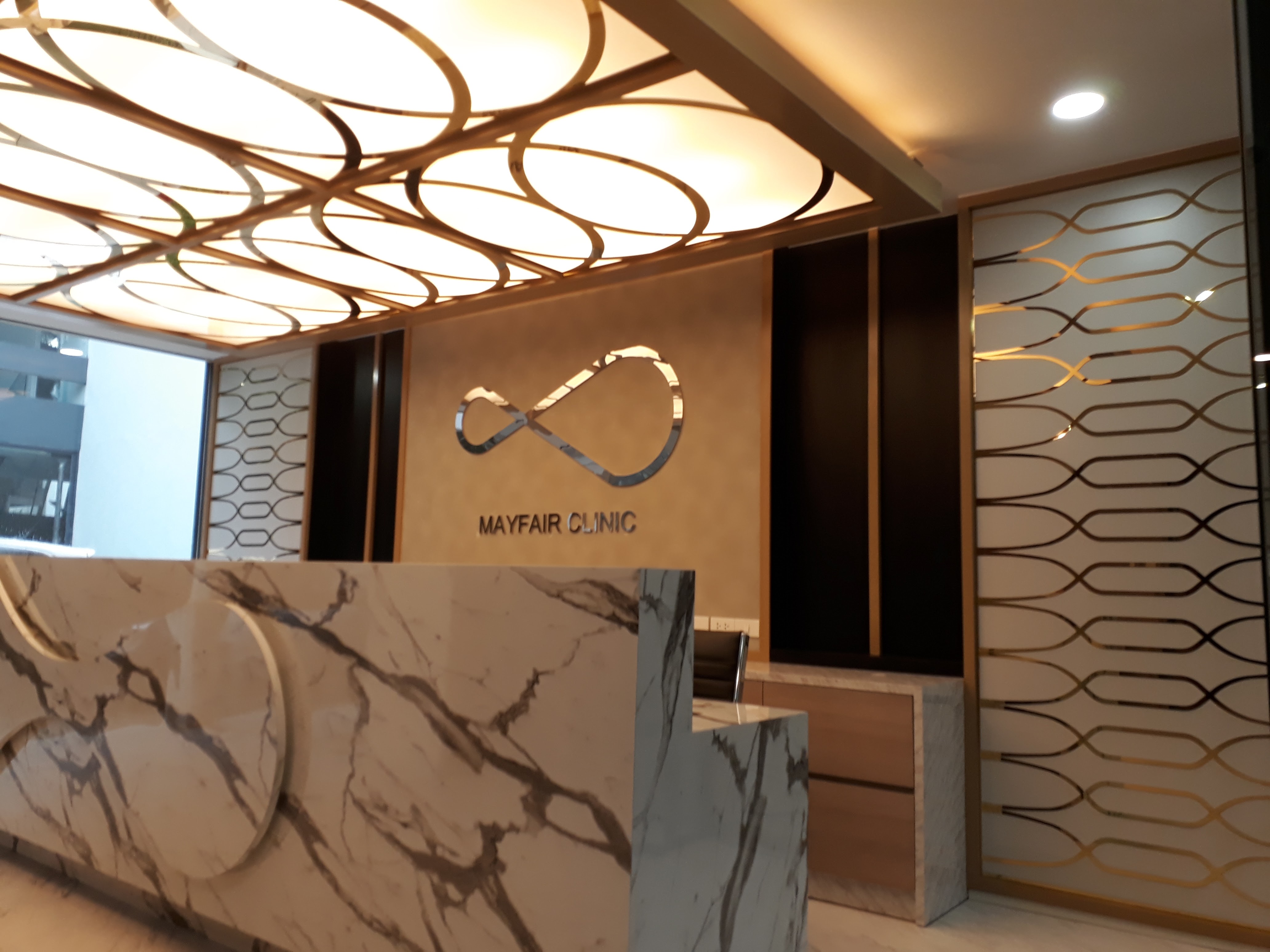 งานผลิตติดตั้ง MAYFAIR CLINIC ฉลุแผ่นไทเทเนี่ยมทองเงา 1 มม. ยึดแผ่นอะคลิลิค 3 มม. พร้อมติดตั้งราคาโรงงาน