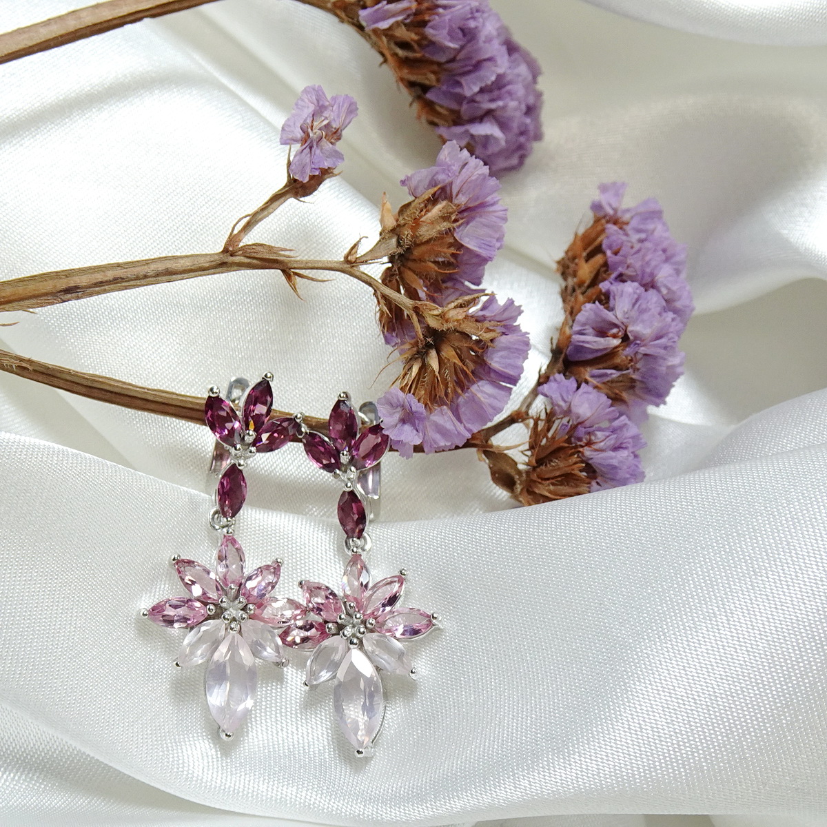 ต่างหูพลอยระย้าเฉดชมพูม่วง เก๋ด้วยพลอยทรงมาคีทุกเม็ด ตัวเรือนฝังพลอยโรโดไลท์สีม่วงอมชมพู ห้อยด้วยทัวร์มาลีนสีชมพูไล่เฉดชมพูเข้มอ่อนของโรสควอทซ์ สวยหวานละมุน