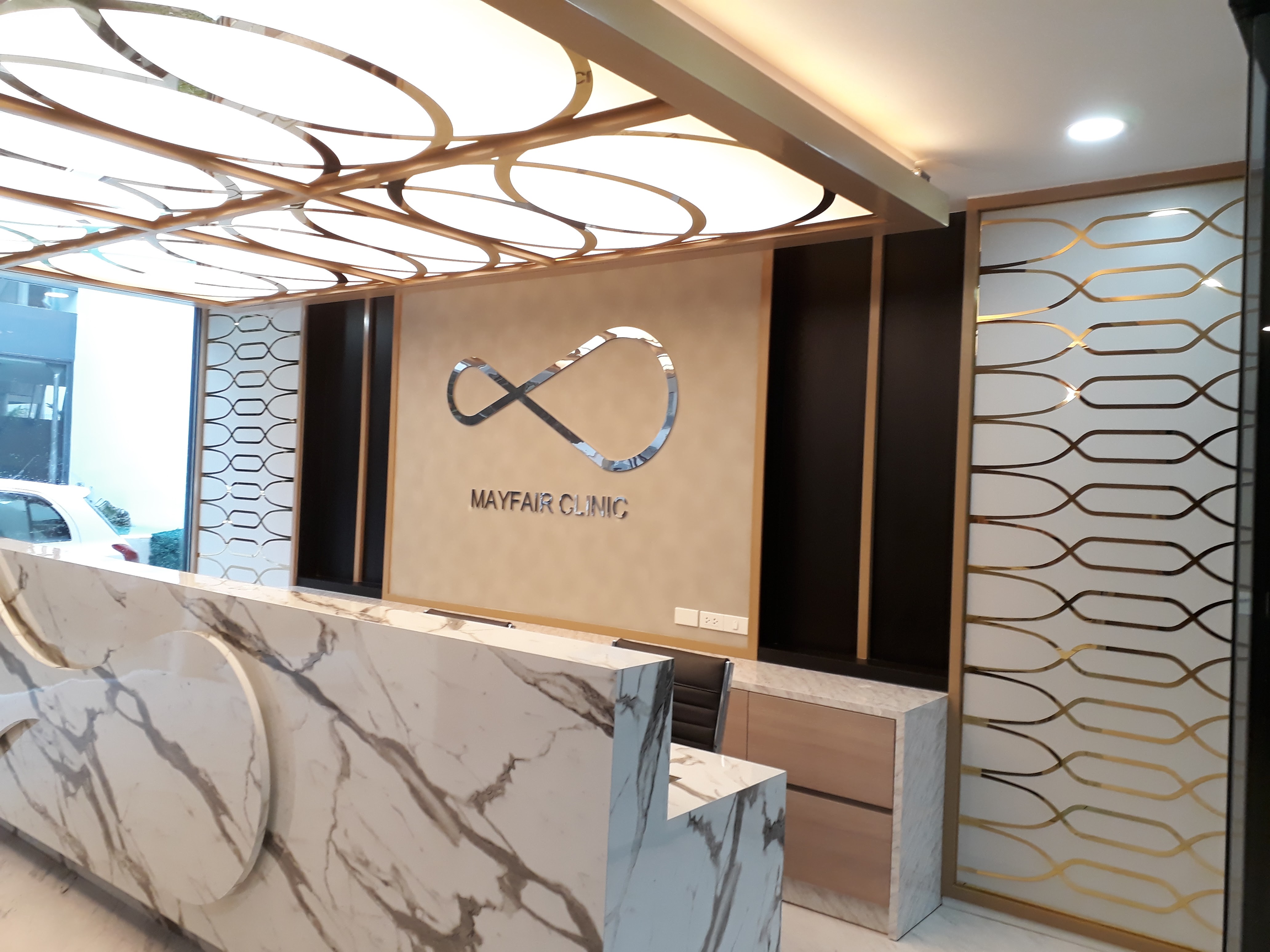 งานผลิตติดตั้ง MAYFAIR CLINIC ฉลุแผ่นไทเทเนี่ยมทองเงา 1 มม. ยึดแผ่นอะคลิลิค 3 มม. พร้อมติดตั้งราคาโรงงาน