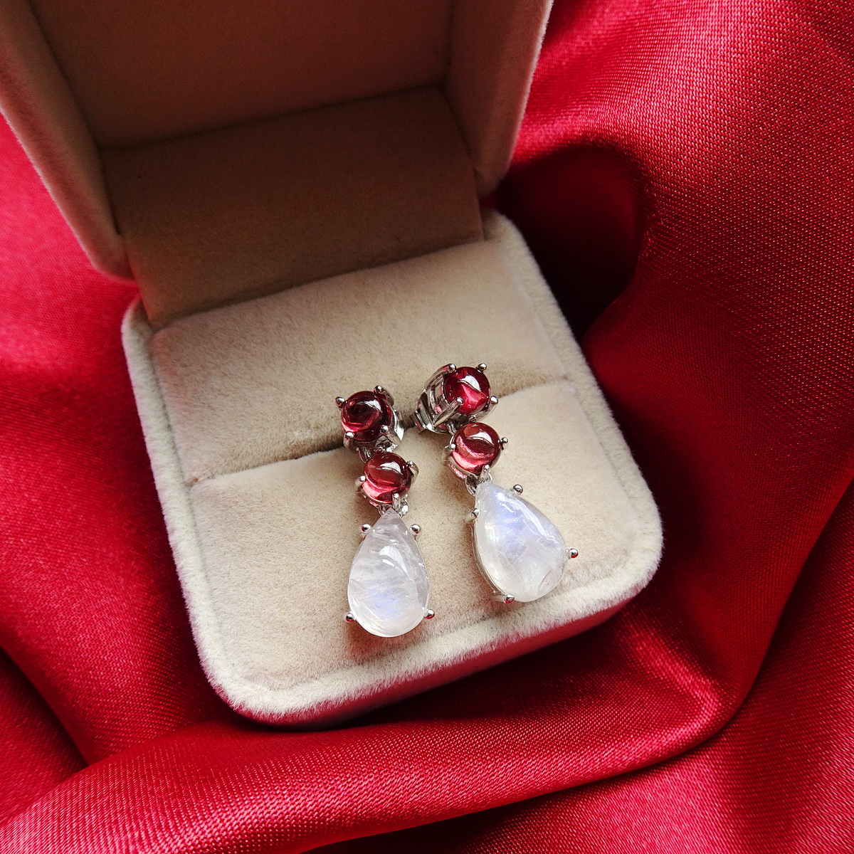 ต่างหูห้อยเรนโบว์มูนสโตน หรือมุกดาหารทรงลูกแพรหรือหยดน้ำ อัญมณีประจำราศีเมถุน ให้สีสะท้อนแสงเหลือบรุ้ง ด้านบนฝัง'โกเมนหรือการ์เนทท์สีแดงอมน้ำตาล ตัดกับสีขาวรุ้งของมูนสโตน สวยงามมากค่ะ