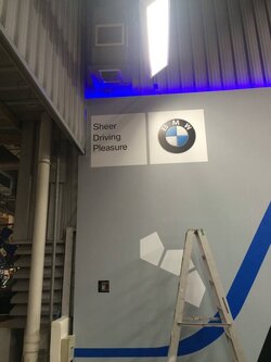 งานผลิตติดตั้ง โรงงาน BMW โครงสร้างเหล็กยึดผนัง กรุแผ่นพลาสวูด 10 มม. โปีวเก็บสี ติดสติกเกอร์ พร้อมติดตั้งราคาโรงงาน